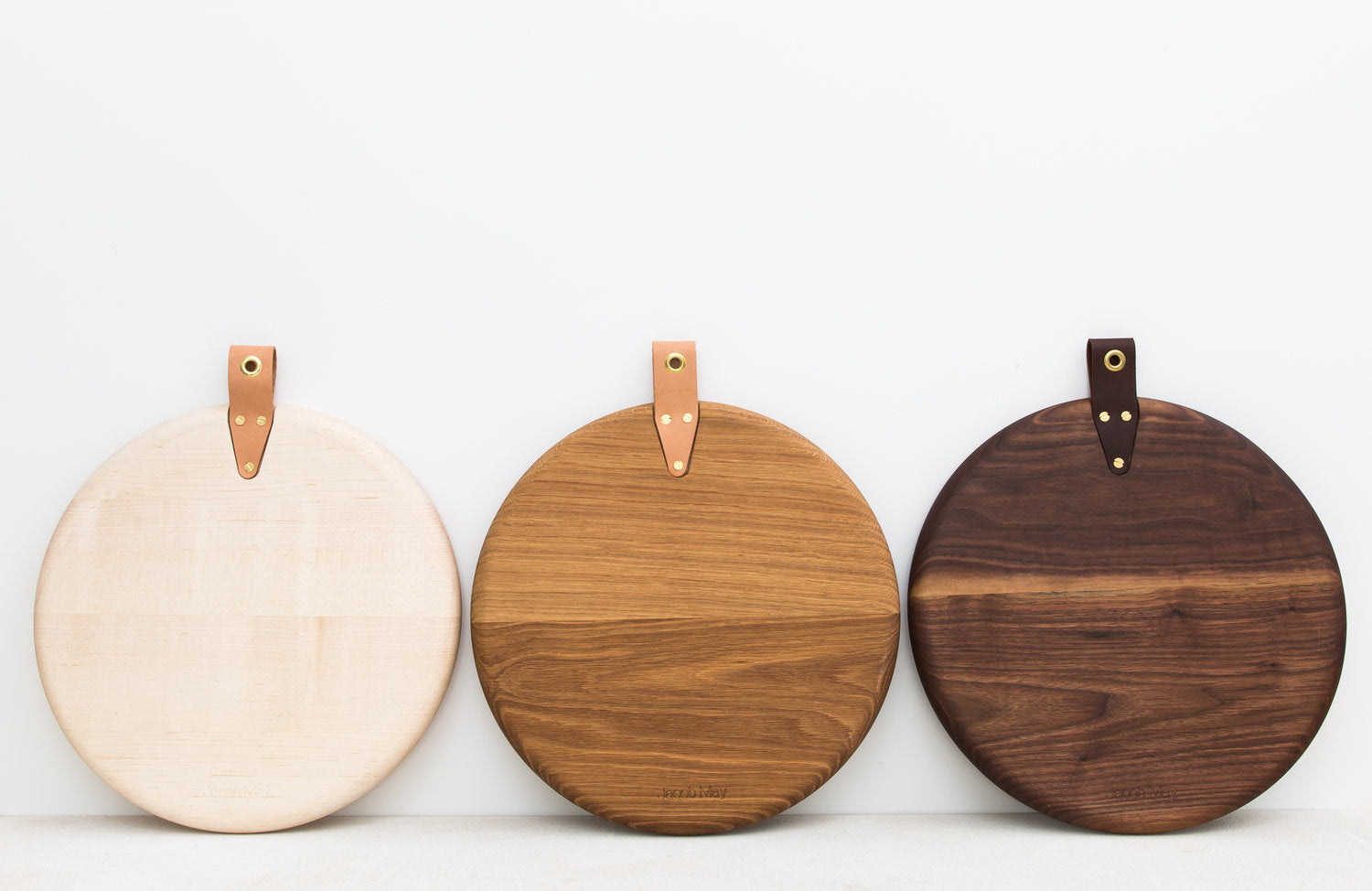 Three Round Cooper Bread Boards Leaning Against a Wall