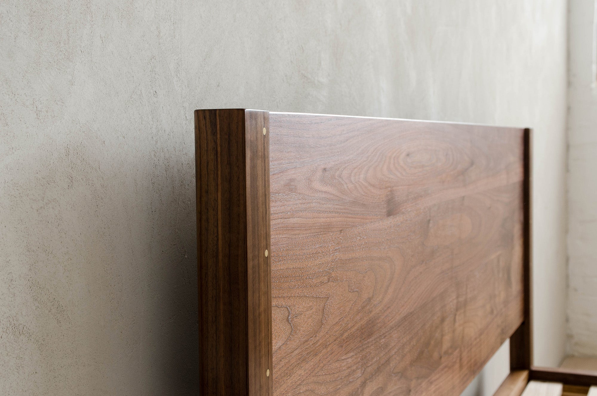 Closeup Details of Lore Headboard Against Concrete Wall