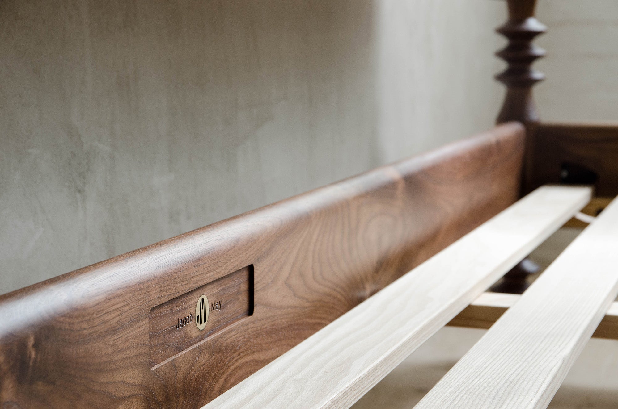 Closeup of Jacob May Logo and Brass Details in Walnut Bed Frame