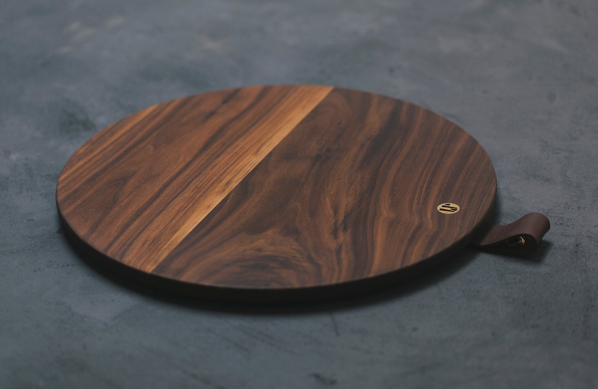 Round Cooper Bread Boards Black Walnut Laying on Dark Countertop