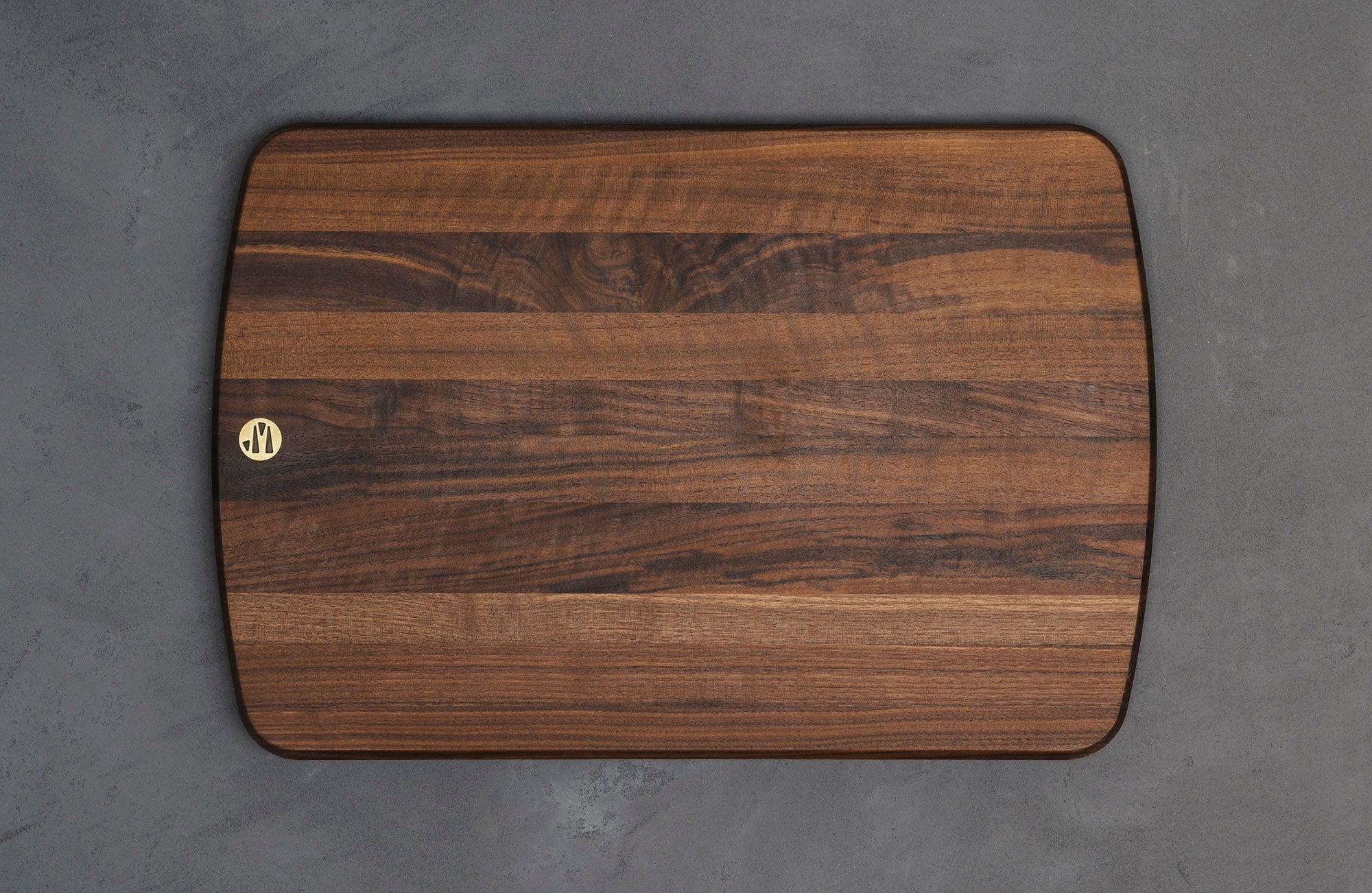 A Hudson Cutting Board in Black Walnut With Brass Jacob May Logo
