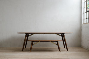 Nomad Bench in Natural Walnut Stacked Under Nomad Table