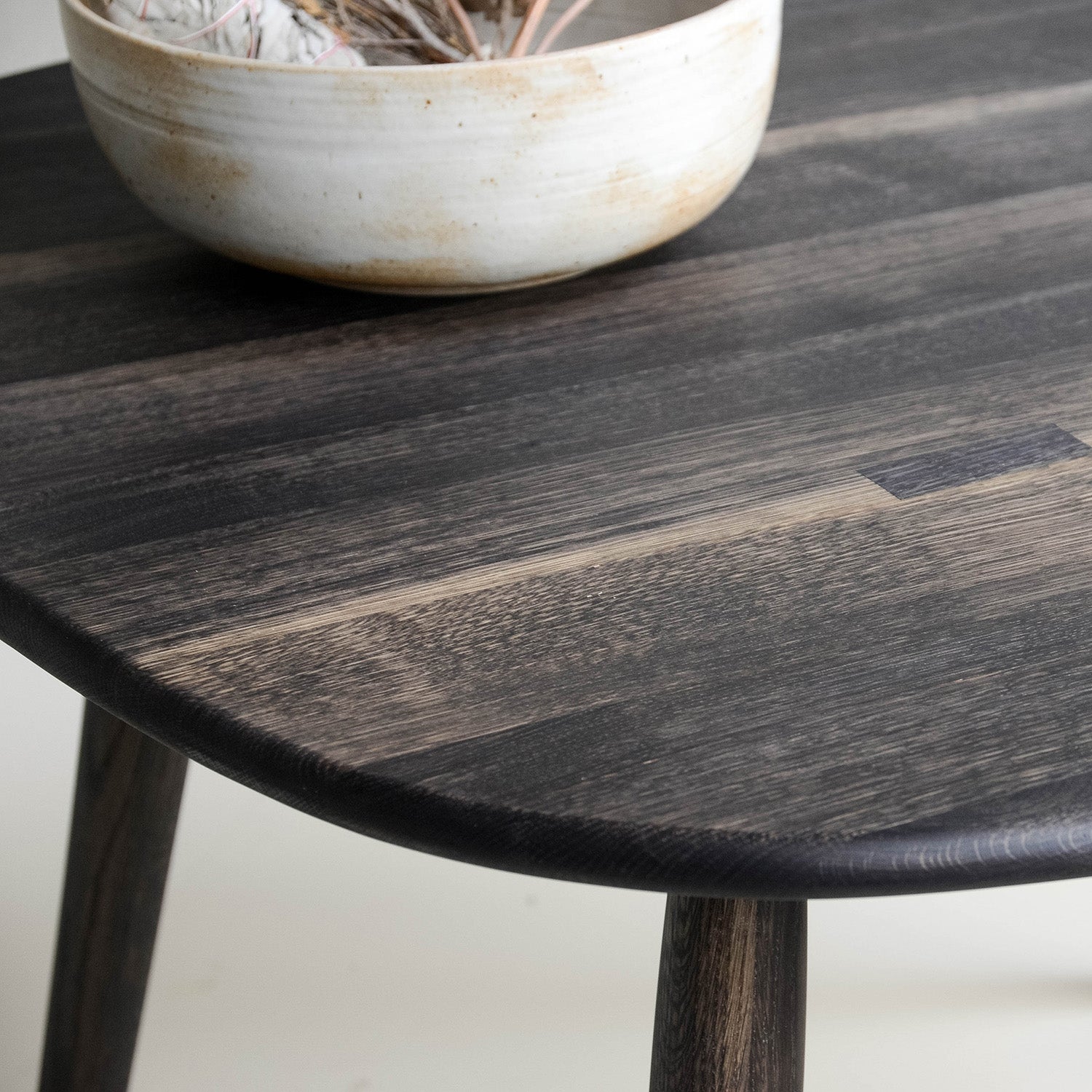 Closeup of Oxidized Oak Nomad Round Dining Table With Bowl