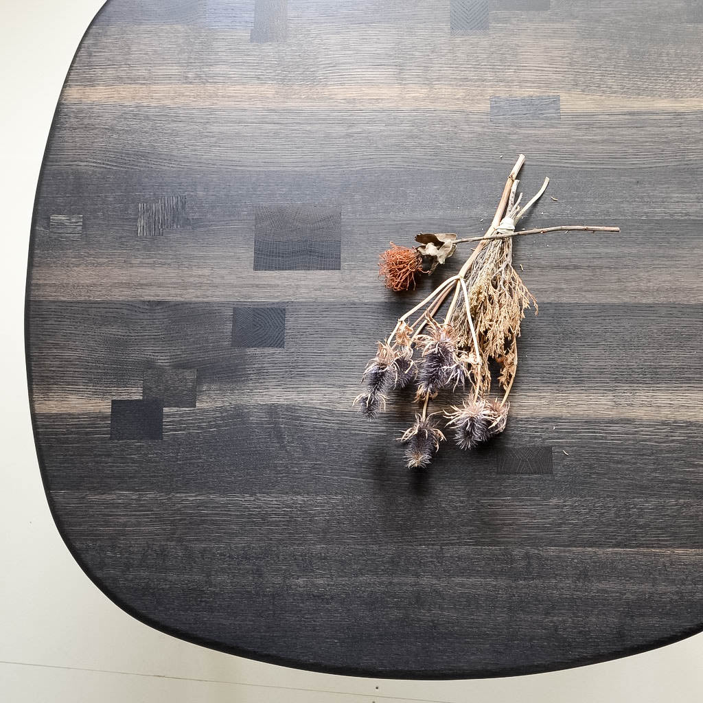 Top of Nomad Round Dining Table in Oxidized Oak With Dried Flowers