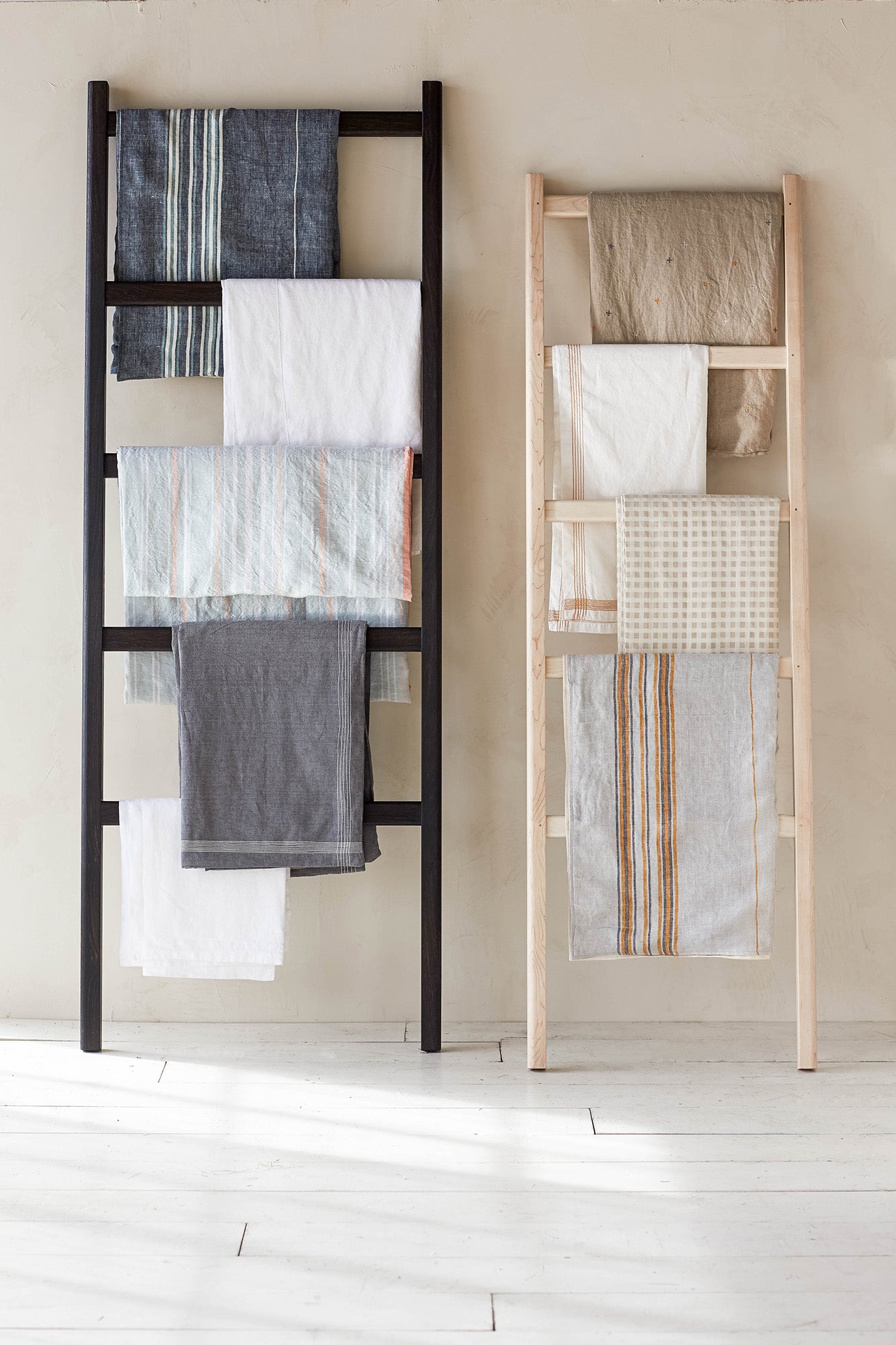 Two Lore Ladders Against Wall With Linen Towels Hanging on Them